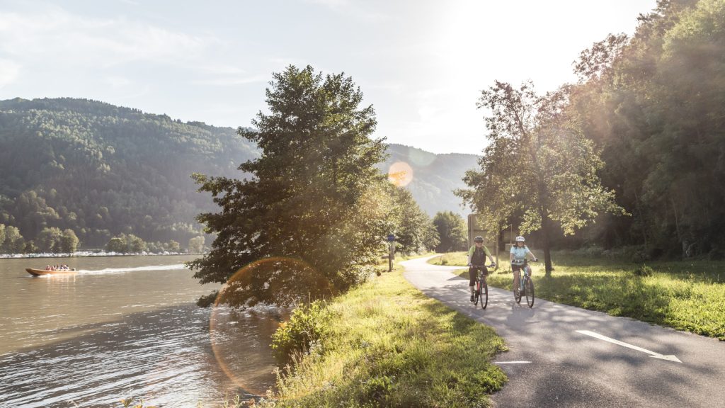 Radfahrer fahren eine Strecke entlang dem Donauufer in Oberösterreich