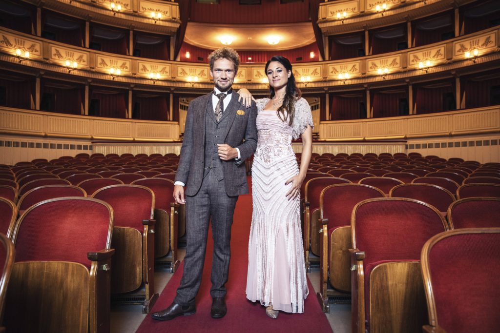 Ein Mann und eine Dame stehen in Abendkleidung in der Wiener Staatsoper.