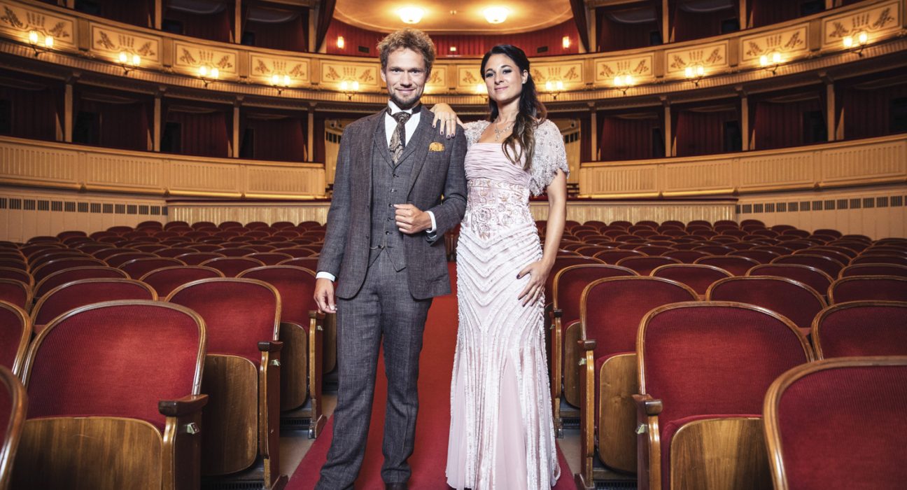 Ein Mann und eine Dame stehen in Abendkleidung in der Wiener Staatsoper.
