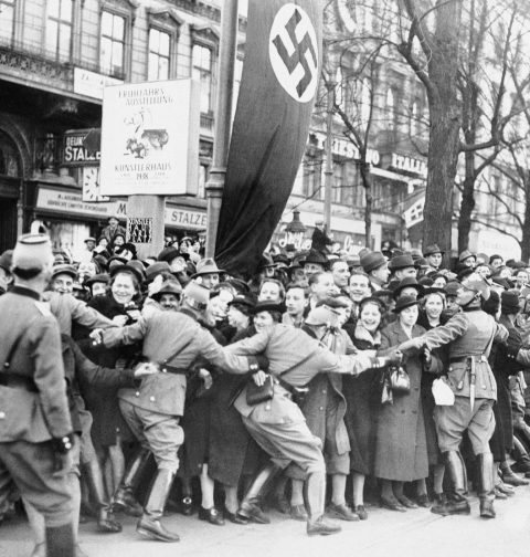 Historisches Foto von Wien 1938: Menschenmenge, die Adolf Hitler begrüßen will, wird von Polizisten zurückgehalten