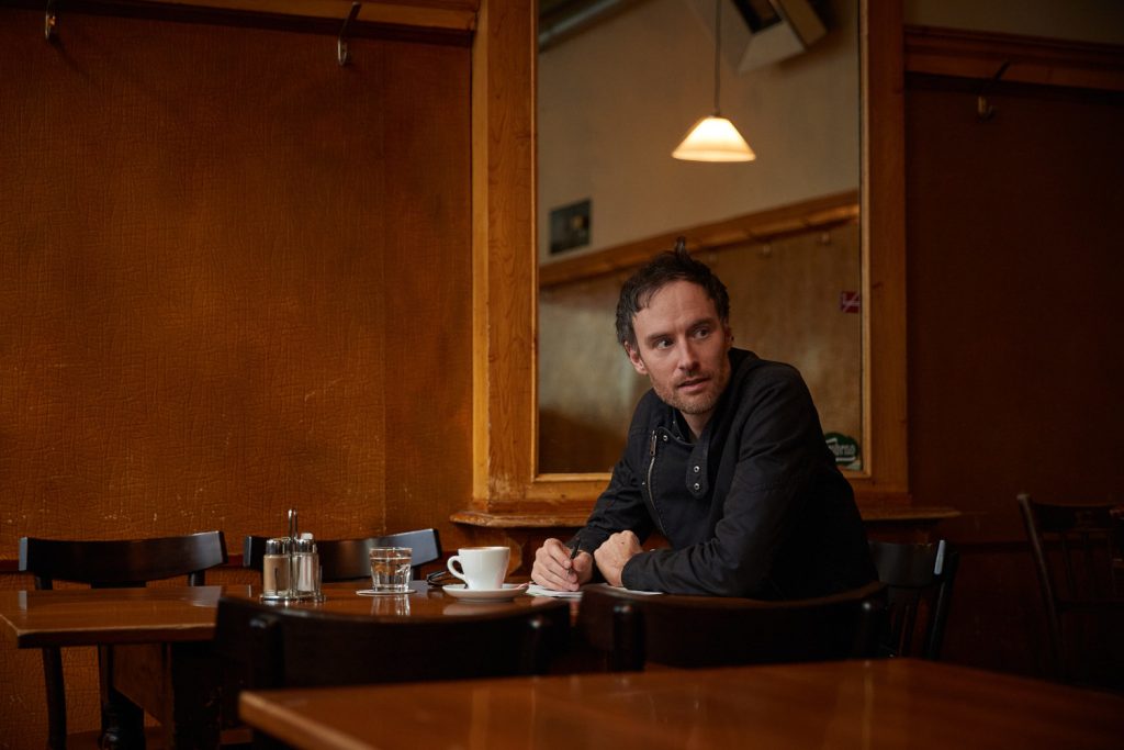 Andreas Rainer von den Wiener Alltagspoeten sitzt in einem Cafe.